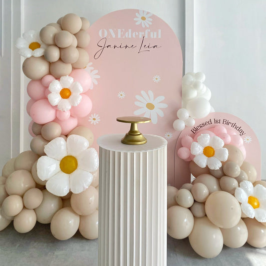 Balloon arch with floral decorations and personalized signs on a white background